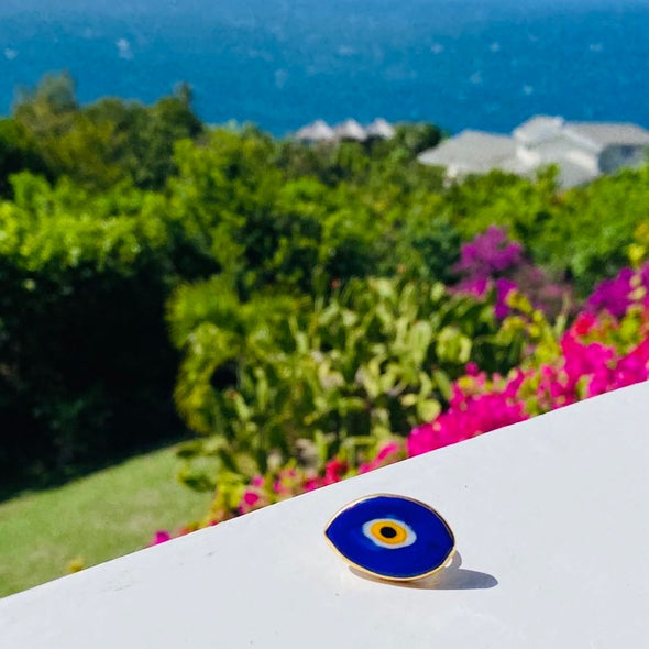 Evil eye glass gold plated ring with garden background